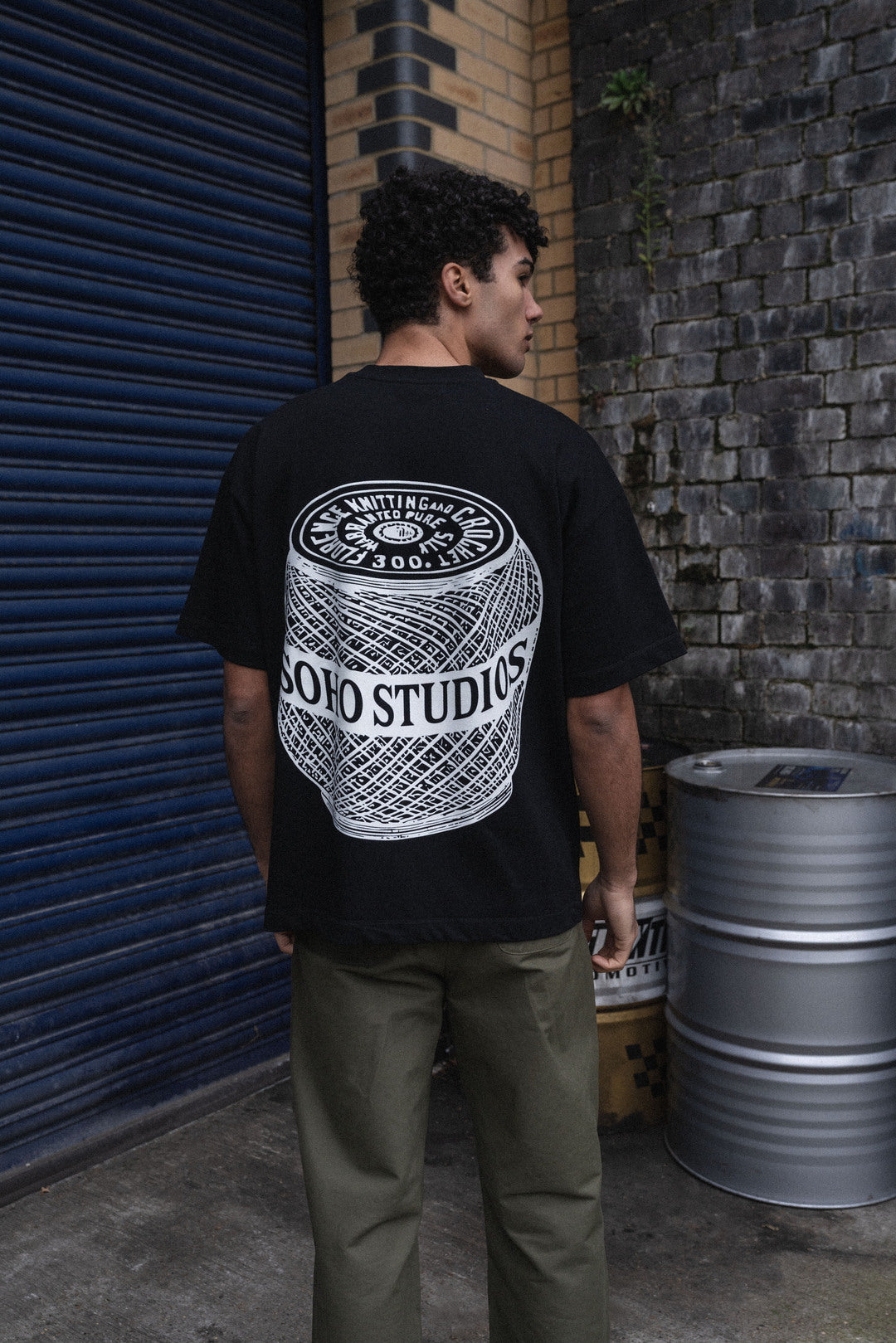 Men Wearing a BLACK 'SPOOL' T-SHIRT showing his back
