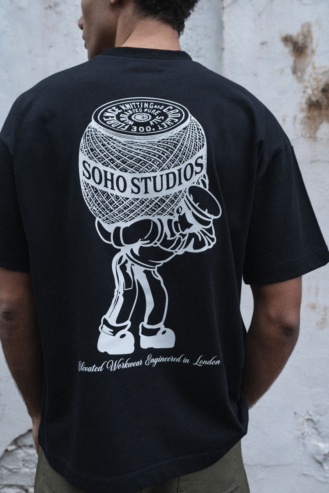 Black Soho Studios graphic t-shirt with oversized yarn spool back print
