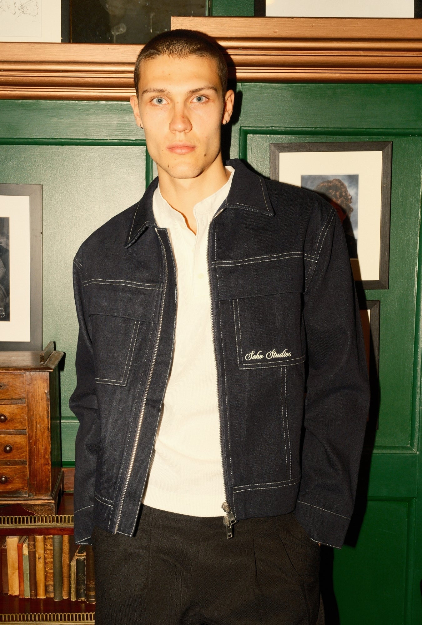 Man wearing a black jacket with a brand logo in an indoor setting