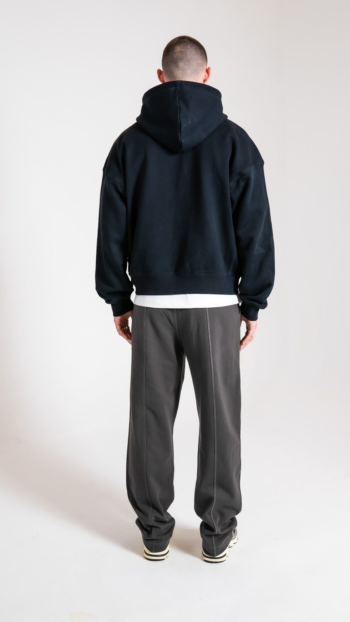 Man wearing black Soho Studios zip hoodie with grey logo sweatpants