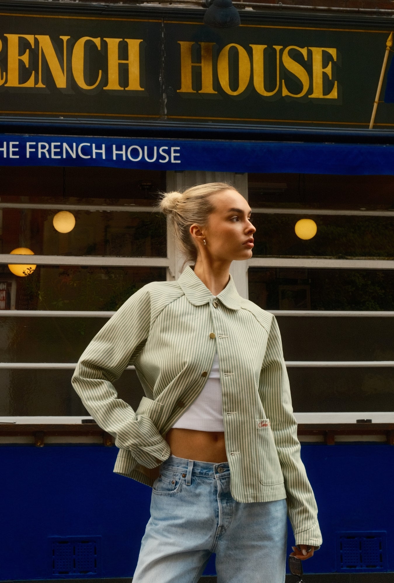 Woman standing in front of a building with 'The French House' sign