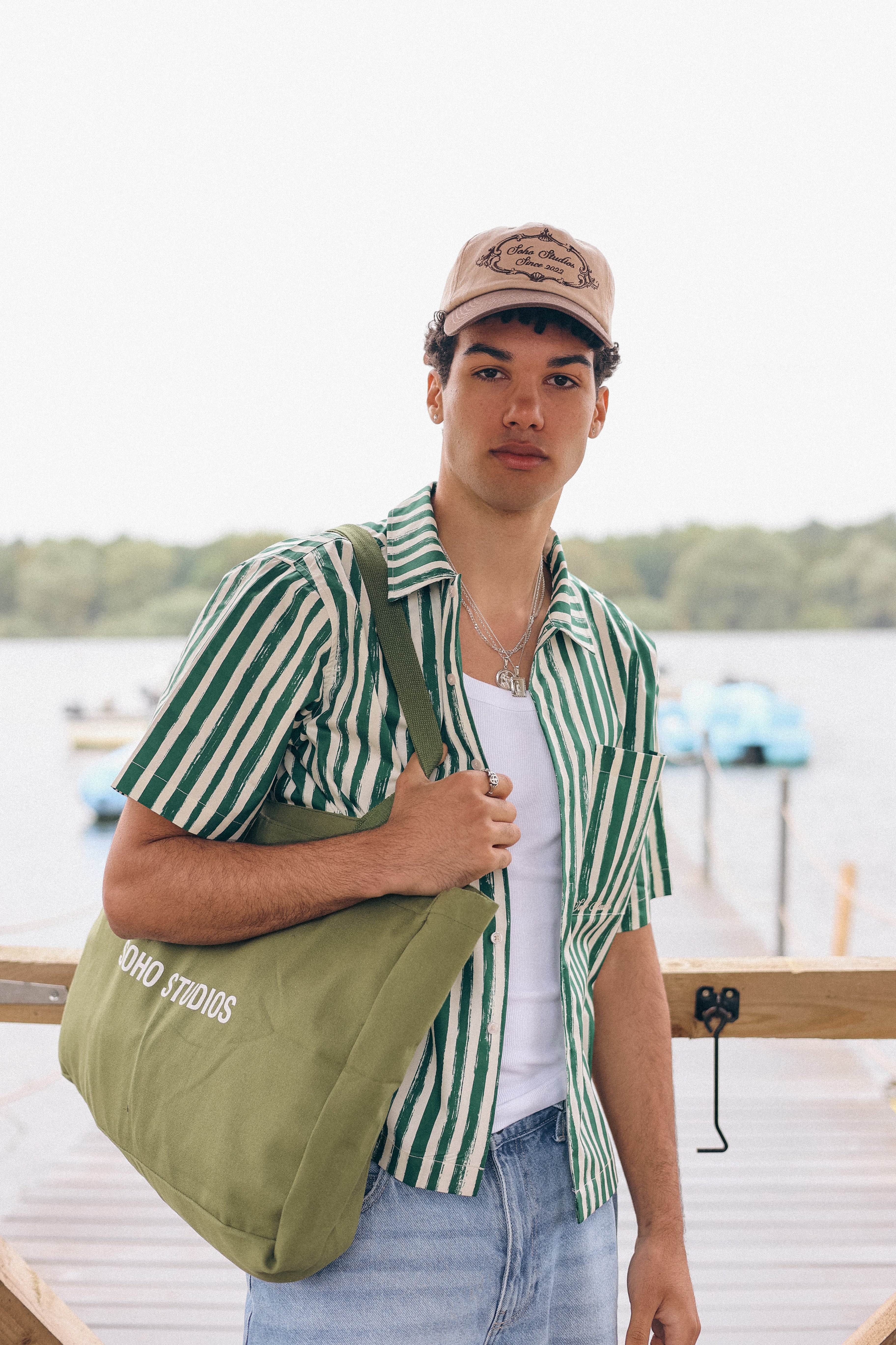 Men carrying OLIVE GREEN tote bag with 'SOHO STUDIOS' printed in black on the front.