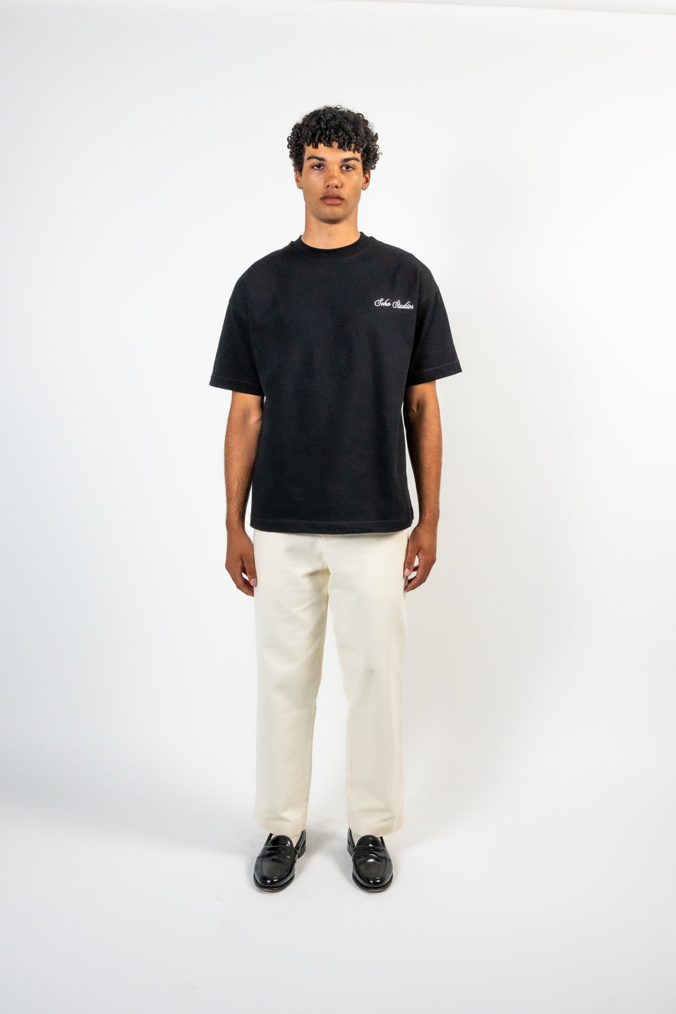 Men wearing A black t-shirt with striped detailing and an embroidered logo on the left chest.